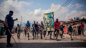 Demonstrators carrying a poster honouring DRC armed forces march during a protest in Goma
