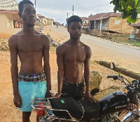 The convicts standing beside the stolen motorbike