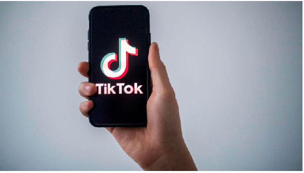 A man shows a smartphone with the logo of social network TikTok
