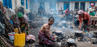 Anociata Nyiranzarura prepares food for her displaced family at a schoolyard shelter