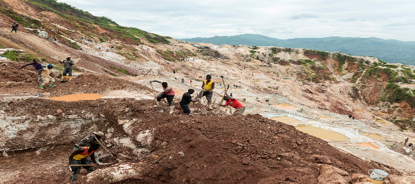 Labourers dig a new washing pool to be used in mineral processing