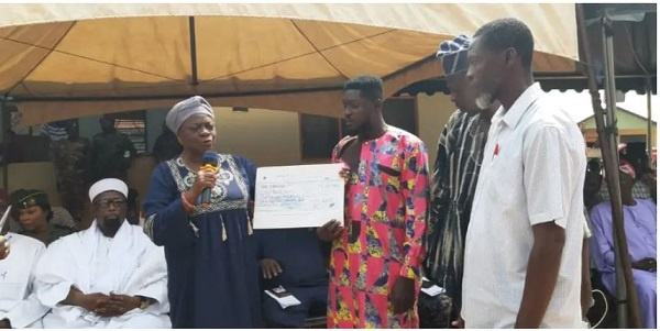 A government official hands over a cheque to a beneficiary during the presentation