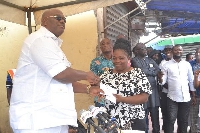 Mr Quartey (left) presenting the cash to one of the victims