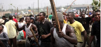 People holding sticks during an ethnic conflict