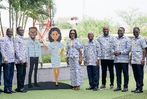 Some board members and management pose with a human cut out