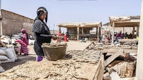 A woman arranges dried fish at a deserted fish market
