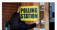 Polling staff for di Agape Centre for south Belfast make sure voters know wia to go