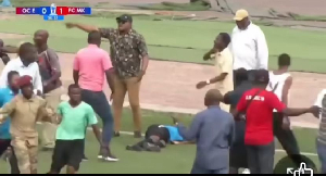 The referee on the floor surrounded by angry fans