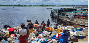 People gather among the belongings of passengers from a capsized boat on the Congo River