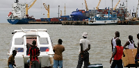People gather around a speedboat of a type believed to be used by drug traffickers