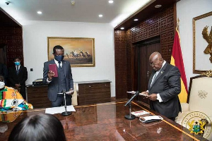 President Akufo-Addo (R) swearing Kissi Agyebeng (with a Bible) into office in 2021
