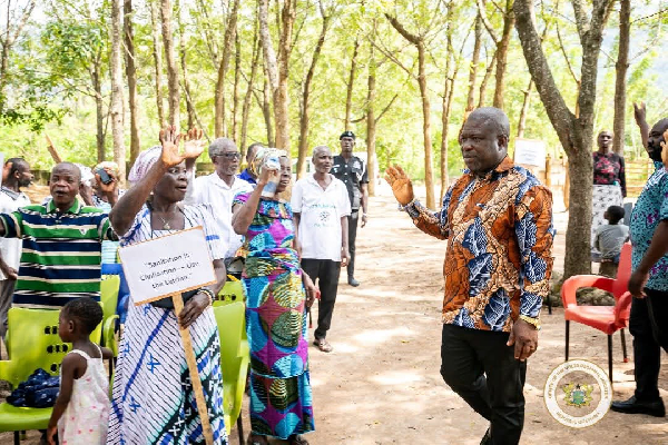 James Gunu (R) interacting with some residents of the Volta Region