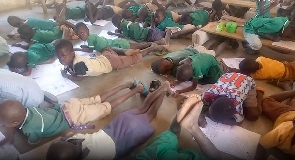 Some of the pupils taking an exam on the bare floor