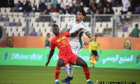 A Ghana player fends off an opponent