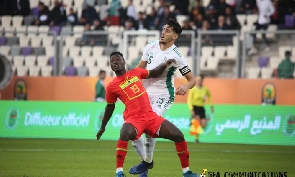 A Ghana player fends off an opponent