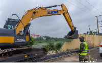 An exacavator is seen demolishing a wall
