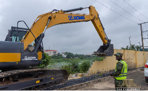 An exacavator is seen demolishing a wall