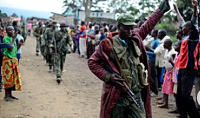 A Congolese army soldier responds to cheers from civilians as the army enters the town of Bunagana
