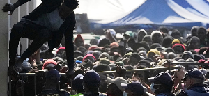 A Malawian migrant jumps over a barricade as the police officer manage the queue A Malawian migrant jumps over a barricade as the police officer manage the queue