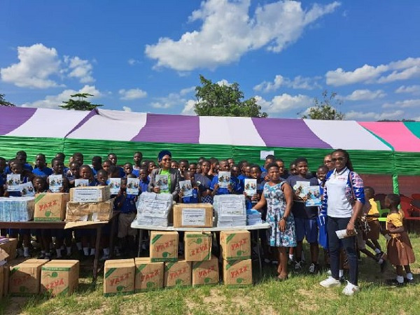 Basic pupils displaying the books donated to them