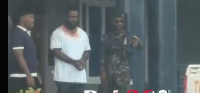Okatakyie Afrifa-Mensah seen wearing handcuffs while being led into the police station