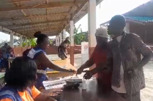 Visually impaired man being assisted to cast his vote