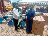 MCE for Yilo Krobo, Francis Addo Akumatey presenting an item to a beneficiary