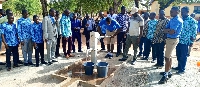 Dr Bandim watches on as a student pump out water from the borehole