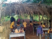 Class Six pupil of Bueyonye M/A Basic School study under palm tree shed