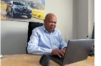 Isuzu Motors South Africa President and CEO Billy Tom works on his laptop