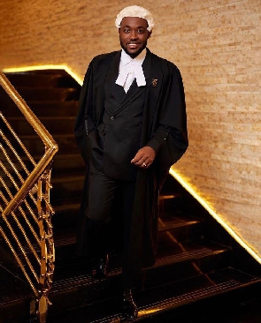 Kennedy Osei dressed in black and white with his peruke