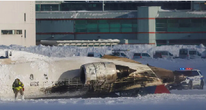 Damaged plane of Delta Airline wey crash for di runway for Toronto Pearson Airport after di crash