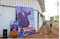A man walks past a campaign billboard of President and presidential candidate Faustin-Archange