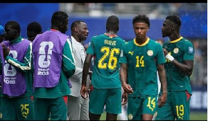 Senegal head coach Pape Thiaw talks with his players during a hydration break of the World Cup
