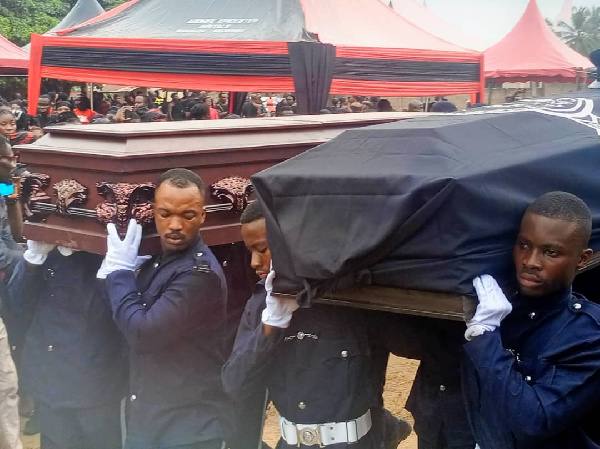 The coffins of the late officer and his wife being carried by pallbearers