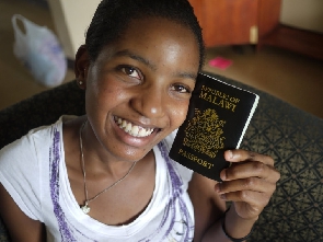 A young girl holding her passport