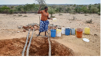 A woman in Mudzi draws water at a village well, which has very limited reserves of water remaining