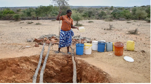 A woman in Mudzi draws water at a village well, which has very limited reserves of water remaining