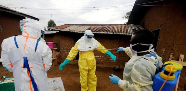 A healthcare worker, who volunteered in the Ebola response, decontaminates his colleague