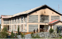 Security officers stand outside a burnt dormitory at the Utumishi Girls' Academy Senior School