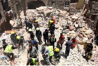 Rescuers search through the rubble of a collapsed five-story apartment building in Cairo