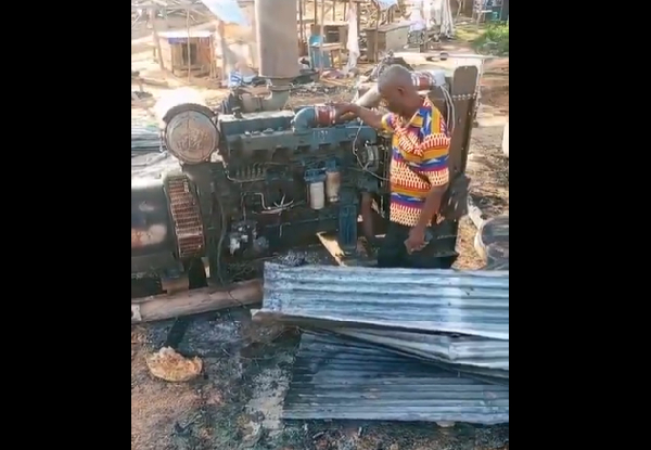The illegal miner standing by his burnt machine