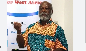 Prof  Kwame Karikari makes hand gestures whiles speaking at an event