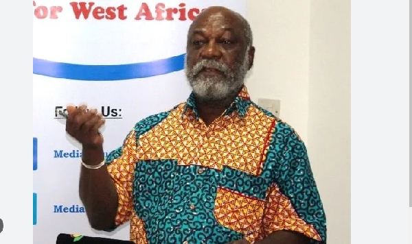 Prof  Kwame Karikari makes hand gestures whiles speaking at an event
