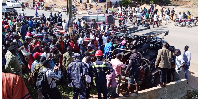 Residents gather as police remove the bodies from the scene on July 14, 2024.