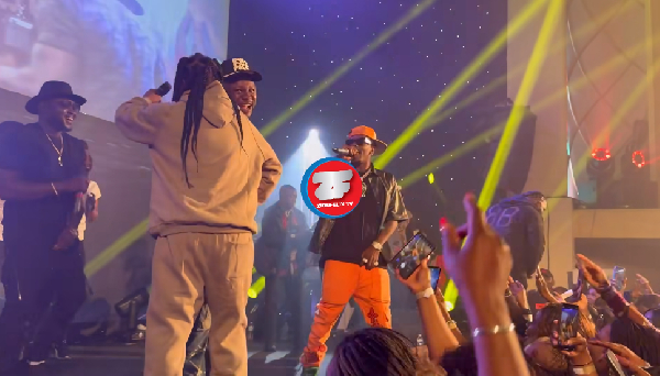Lumba (back to camera) hugs Medikal as Shatta prepares to perform