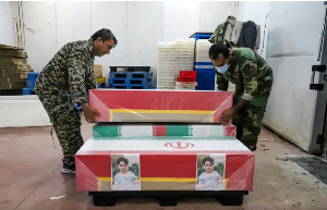 Mourners prepare the coffins of children who were killed in a strike on a primary school in Iran
