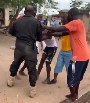 A police officer being attacked by some residents of Amasaman in Accra