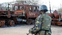 A security forces soldier walks past a burned truck at the port of Mocimboa da Praia, Mozambique