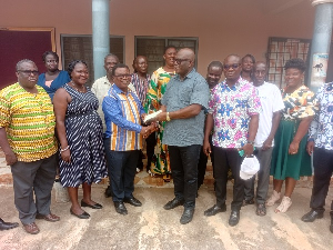 Ebenezer Okletey Terlabi presenting the money to the directorate